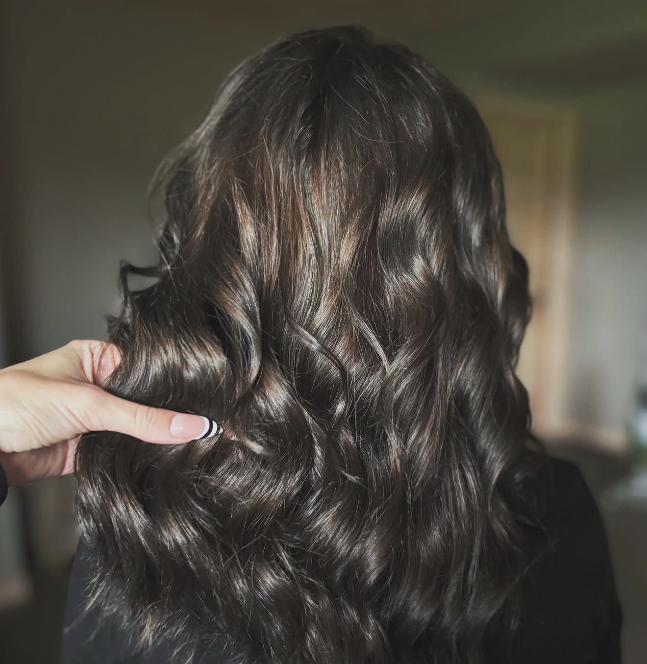 Glossy brunette hair styled in loose waves